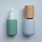 Green Glass Skincare bottle paired with white and bamboo - Ataliene Skincare Private Label